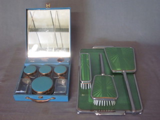 A blue metal framed makeup box with hinged lid and a chrome  and green enamelled 4 piece dressing table set