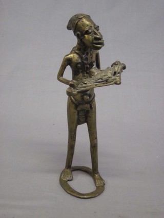 A Mongolian? bronze standing figure of an attendant with candelabrum/dart shaped device 10"