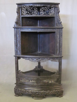 An Eastern pierced ebonised corner cabinet, fitted various recesses, 25"
