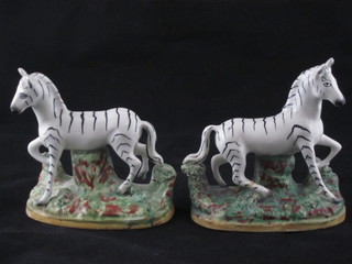 A pair of 18th Century Staffordshire figures of Zebras, raised on  oval bases 5", 1 f and r,
