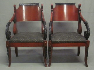 A pair of Empire style mahogany open arm chairs, raised on outswept supports