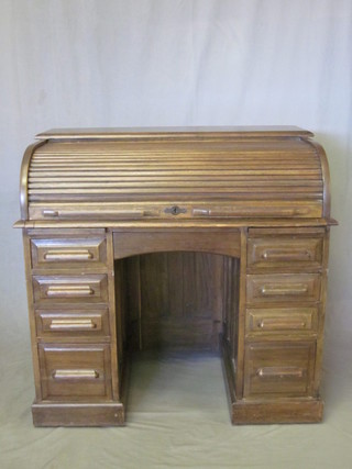 An oak D shaped roll top desk with fitted interior, the pedestal fitted 1 long and 8 short drawers, 42"