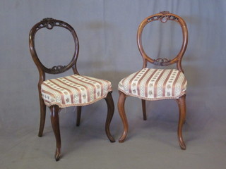 A pair of Victorian pierced mahogany balloon back dining chairs  with shaped mid rails, the seats of serpentine outline, raised on  French cabriole supports