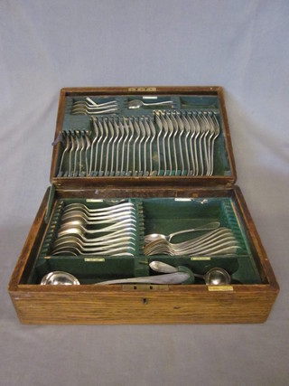 An oak canteen box containing a collection of silver plated flatware by Walker & Hall