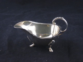 A silver sauce boat with C scroll handle, raised on hoof supports, Birmingham 1923, 3 ozs