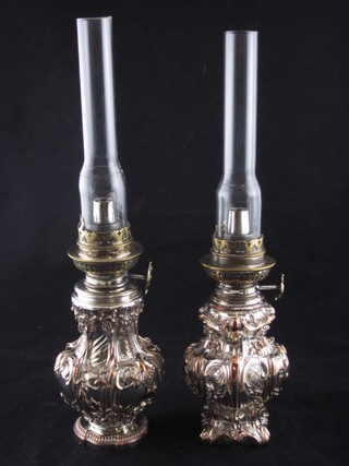 A pair of Victorian embossed silver plated oil lamps complete  with glass chimneys