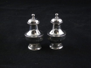 A pair of Victorian silver miniature pepperettes with demi-reeded  decoration, Birmingham 1892