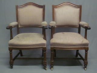 A pair of mahogany show frame open armchairs upholstered in  striped material, raised on turned and block supports