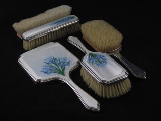 An Art Deco silver and enamelled backed 5 piece dressing table  set with floral decoration comprising pair of hair brushes, pair of  clothes brushes and hand mirror, London 1948