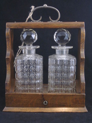 An oak and silver plated 2 bottle tantalus complete with key