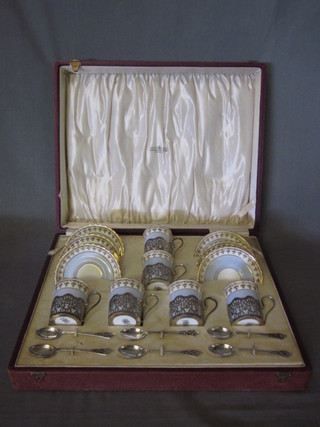 A 6 piece crescent china coffee service with silver mounts and 6 pierced silver coffee spoons, Birmingham 1924, cased