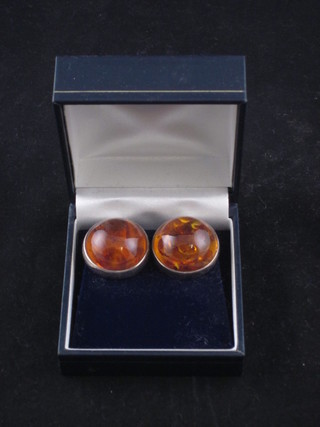 A pair of amber coloured circular ear studs
