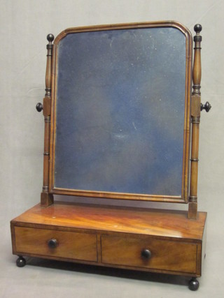 A 19th Century arched plate dressing table mirror contained in a mahogany swing frame, the base fitted 2 drawers, raised on bun  feet 23"