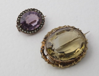 A gilt brooch set an oval cut amber coloured stone and an  "amethyst" set brooch