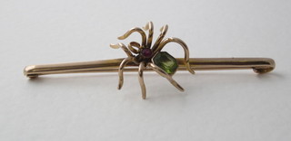 A gold bar brooch in the form of an insect set green and red  stones