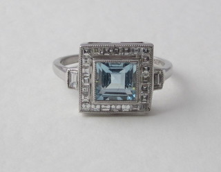 A lady's 18ct white gold dress ring set a square cut aquamarine surrounded by diamonds