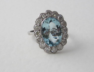 A lady's 18ct white gold dress ring set an oval cut aquamarine surrounded by numerous diamonds, approx 1.55/5.08ct   ILLUSTRATED