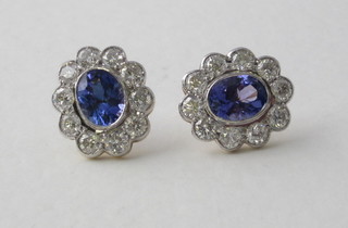 A pair of oval cut tanzanite earrings surrounded by diamonds, approx 2.05/2.55ct