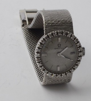 A lady's Omega cocktail wristwatch contained in an 18ct white  gold case, the bezel set diamonds, on an integral bracelet