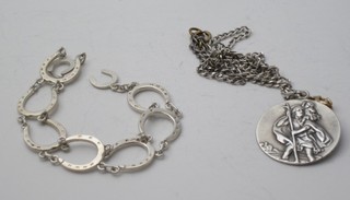 A silver bracelet in the form of horse shoes and a silver St  Christopher medal hung on a fine silver chain