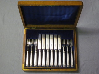 A set of 12 silver fruit knives and forks, Sheffield 1910 contained in an oak canteen box