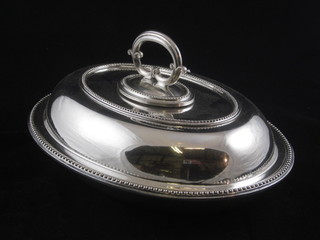 An oval silver plated entree dish and cover with beadwork  border