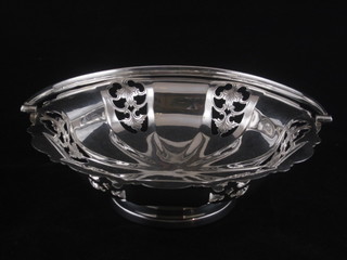 A circular pierced silver plated cake basket with swing handle,  raised on a spreading foot 9"