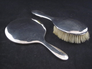 A silver backed hand mirror and a do. hair brush