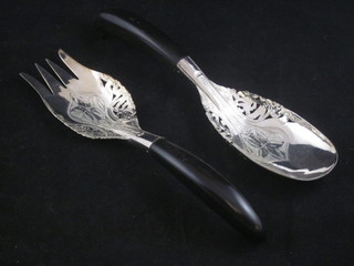 A pair of Eastern pierced white metal salad servers with horn handles