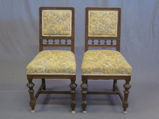 A set of 4 carved walnut dining chairs with upholstered seats and backs and bobbin turned decoration