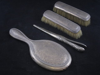 A 4 piece silver backed dressing table set comprising pair of clothes brushes, hand mirror and glove stretchers