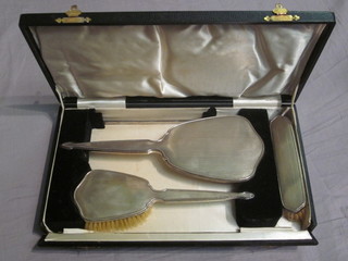 A silver backed 3 piece dressing table set with engine turned decoration comprising comb mount, hand mirror, hair brush and  clothes brush