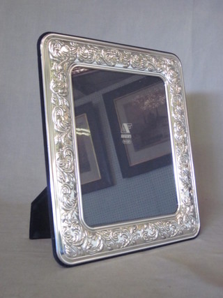 A modern silver easel photograph frame with embossed  decoration 13" x 11"