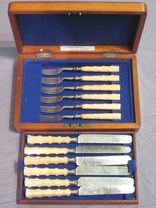 A set of 6 Victorian silver plated dessert knives and forks with ivory handles contained in a walnut canteen box