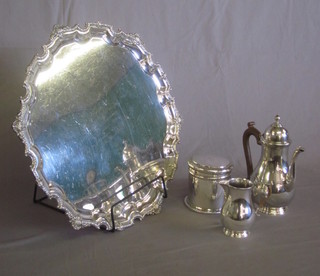 A silver plated salver raised on scroll feet with inscription, a jar and cover, a coffee pot and cream jug