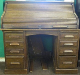 A Victorian honey oak kneehole pedestal roll top desk with  shaped top, the base fitted 1 long and 8 short drawers 49"