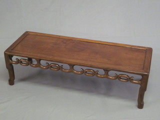 A rectangular Oriental Padouk occasional table with pierced  apron, raised on turned supports 43"