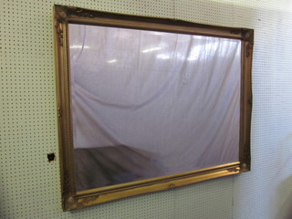 A rectangular bevelled plate wall mirror contained in a decorative  gilt frame 54"