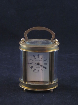 An oval shaped miniature carriage clock with enamelled dial and Roman numerals by Elliott & Sons, contained in a gilt metal case