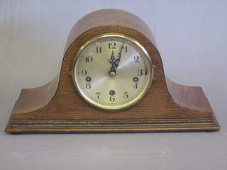 A chiming mantel clock with silvered dial and Arabic numerals contained in a honey oak Admiral's hat shaped case