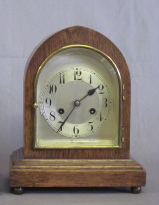 An Edwardian 8 day striking bracket clock with silvered dial and Arabic numerals by Unghans, contained in an oak lancet case   ILLUSTRATED