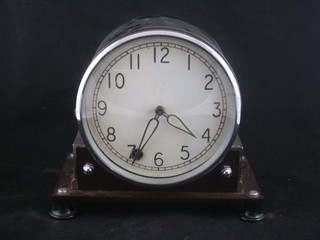 A mantel clock with plastic dial with Arabic numerals contained  in a metal case 9"