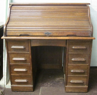 A Victorian oak kneehole pedestal roll top desk with shaped top  and tambour shutter and well fitted interior 31"