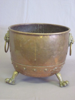 A circular copper coal bin with brass lion mask handles, raised  on paw feet 16"