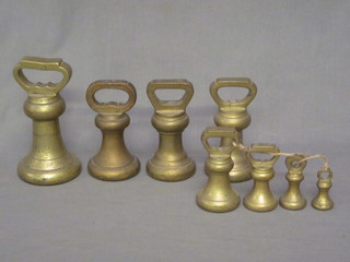 A 7lb brass bell weight, 3 x 4lbs brass bell weights and 4  graduated brass bell weights