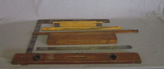 A rolling ruler boxed, a large metal square, a wooden ruler, 2  metal rulers, a brass and mahogany spirit level by J Rabone &  Sons and 2 folding wooden gauges