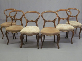 A set of 6 Victorian bleached walnut balloon backed dining chairs with shaped mid rails and seats of serpentine outline, raised on  cabriole supports