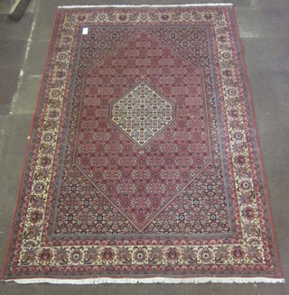 A red ground and floral patterned Persian style carpet 112" x 79"