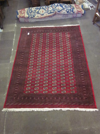 A contemporary red ground Bokhara carpet with 138 octagons to the centre within a multi row border 122" x 87", some damage to  the edges