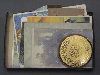 A gilt metal compact and a collection of postcards